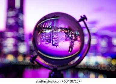 Crystal globe with blur background and reflection of cityscape and landscape inside