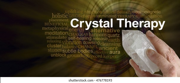 Crystal Therapy Word Cloud - Female hand pointing a clear quartz terminated crystal surrounded by a CRYSTAL THERAPY word cloud on a rich dark golden spiraling  vortex background