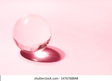 Crystal, Transparent Ball, Sphere On A Pink Background.