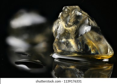 Crystalline THCa Resting In A Pool Of Terpenes On Black Acrylic.