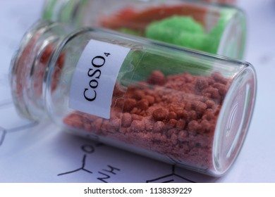 Crystals Of Red Salt Of Cobalt Sulfate In A Transparent Glass Jar.