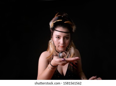 Crytal Ball Gazing In Asian Woman Hand Showing In Selection Focus, With Blurry Background In Dark Room.