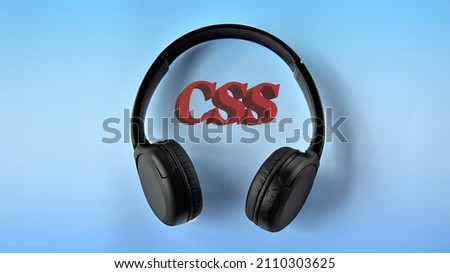 CSS (Cascading Style Sheets) - acronym 3 D on a blue background with wireless headphones. Technology concept