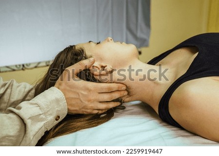 
a CST treatment session for a woman, Osteopathic Manipulation and CranioSacral Therapy. Non-traditional medicine. Health care and head massage