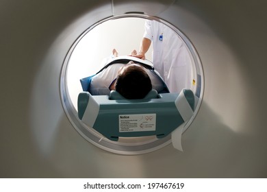 A CT Scan Technician Preparing A Patient For Scanning/ Mri / Machine In Hopital