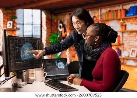 CTO supervisor in artificial intelligence focused startup overseeing worker designing, coding and debugging applications. Team leader supervising employee doing code testing and quality assurance