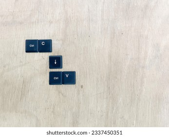 Ctrl C, Ctrl V keyboard buttons, copy and paste key shortcut on a wooden background.