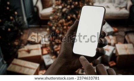 CU African-American Black man checking his phone near Christmas tree