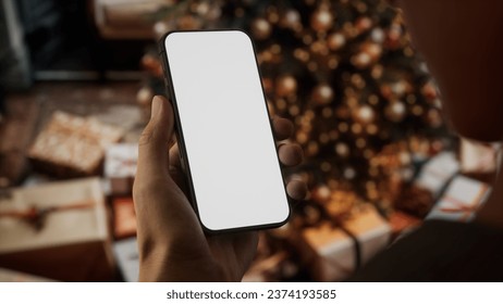 CU Caucasian man checking his phone near Christmas tree - Powered by Shutterstock