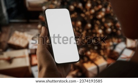 CU Caucasian man checking his phone near Christmas tree