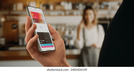 CU Man is paying with a card linked to his smartphone at the cafe using wireless NFC technology - Powered by Shutterstock