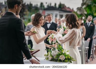 CU View of two LGBT females lesbians brides exchanging rings during wedding ceremony