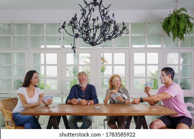 Cuacasian Family Everybody Wearing Face Sheild Enjoying Playing Card Together At Home