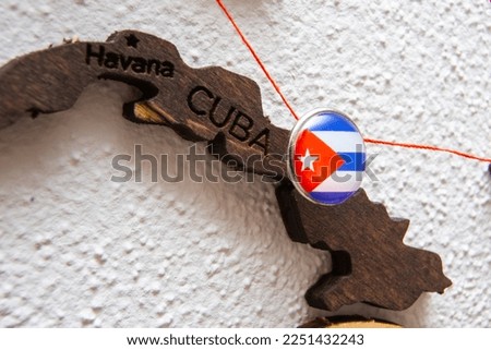 Cuba flag on the pushpin with red thread showed the paths of movement or areas of influence in the global economy on the wooden map. Planning of traveling or logistic concept. Network connection. 