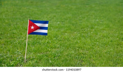 Cuba Flag. Photo of Cuba flag on a green grass lawn background. National Cuban flag waving outdoors. - Powered by Shutterstock