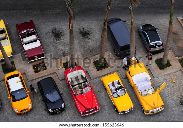 CUBA, HAVANA - JUNE 26, 2013: Aerial view of\
old American cars in front of the hotel. Classic cars are still in\
use in Cuba and old timers have become an iconic view and a\
worldwide known\
attraction
