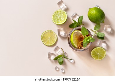 Cuba Libre Alcoholic Drink, Cola With Ice Cubes Or Lemonade On A Pastel Brown Background. Top View Flat Lay Background. Copy Space.