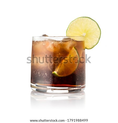 Cuba Libre cocktail with brown rum, lemon juice, coke and ice cubes, decorated with fresh lime slice isolated on white background