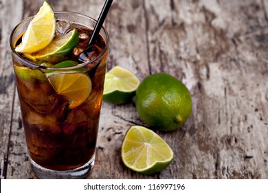 Cuba Libre Drink With Lime On A Wooden Table