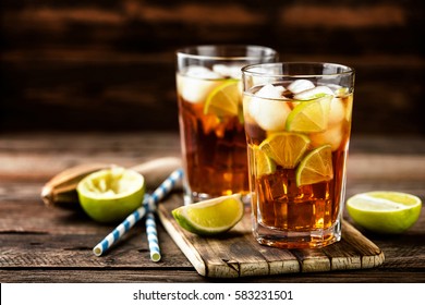 Cuba Libre or long island iced tea cocktail with strong drinks, cola, lime and ice in glass, cold longdrink or lemonade