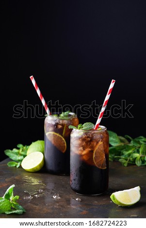 Cuba Libre or long island iced tea cocktail with strong drinks, cola, lime and ice in glass, cold longdrink or lemonade