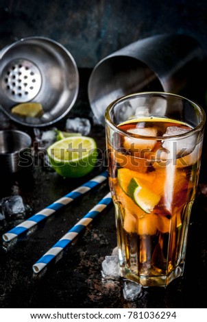Cuba Libre, long island or iced tea cocktail with strong alcohol, cola, lime and ice, two glass, dark background copy space