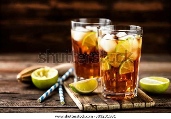 Cuba\
Libre or long island iced tea cocktail with strong drinks, cola,\
lime and ice in glass, cold longdrink or\
lemonade
