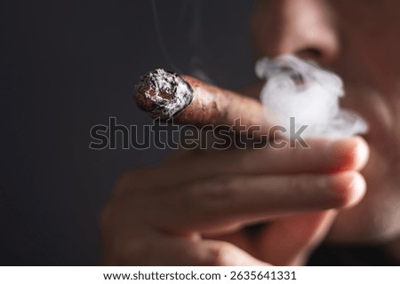 Cuban cigar, Man smoked and holding a cigar in his hand close-up,