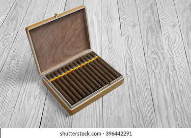 Cuban cigars in the cigar box on a light wooden background