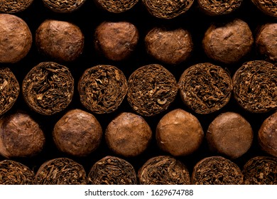 Cuban Cigars: Close up of luxury hand made cigars stacked in a storage box. Tobacco display background or wall art.