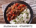 Cuban cuisine: ropa vieja meat with rice garnish on a plate  close-up. Horizontal view from above

