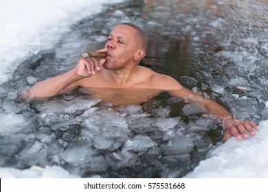 Cuban man swims in an ice hole in winter smoking a cigar