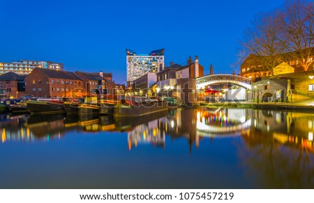 The cube behind brick buildings alongside a water channel in the central Birmingham, England