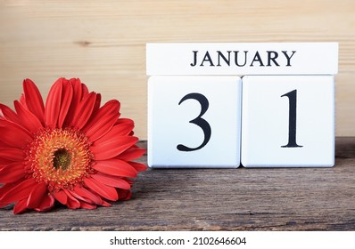 Cube calendar with date January 31st, Wooden calendar with date and beautiful flower on wooden table.