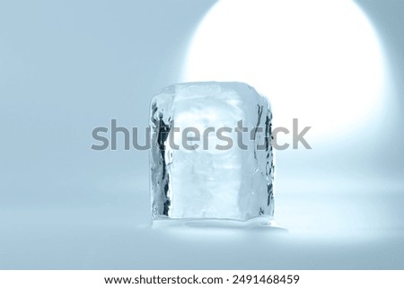 Cube of clear ice on light blue background