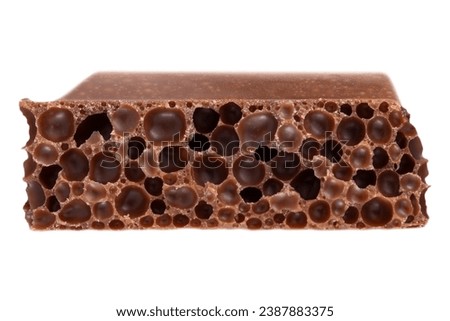 A cube of milk porous chocolate isolated on a white background.