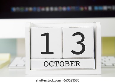 Cube shape calendar for OCTOBER 13 and computer keyboard on table. 