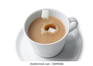 Cube Sugar Dropping Into Cup Of Tea With Milk