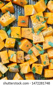 Cubed Butternut Squash On Sheet Pan Covered In Olive Oil, Pepper, Salt, And Parsley, Raw Vegetable In Baking Sheet