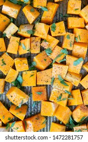 Cubed Butternut Squash On Sheet Pan Covered In Olive Oil, Pepper, Salt, And Parsley, Raw Vegetable In Baking Sheet