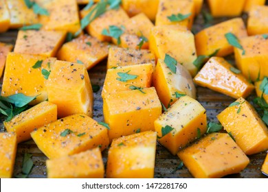 Cubed Butternut Squash On Sheet Pan Covered In Olive Oil, Pepper, Salt, And Parsley, Raw Vegetable In Baking Sheet