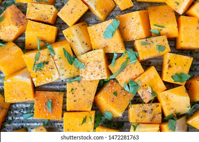 Cubed Butternut Squash On Sheet Pan Covered In Olive Oil, Pepper, Salt, And Parsley, Raw Vegetable In Baking Sheet