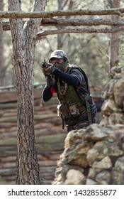 Cubellas, Barcelona, Spain; May 5, 2019: An airsoft player with goggles and protective mask takes aim with his submachine gun in a warlike recreation field facility