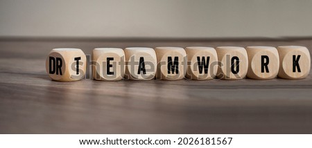 Cubes, dice or blocks with dreamwork and teamwork on wooden background