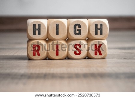 Cubes, dice or blocks with high risk and low risk on wooden background