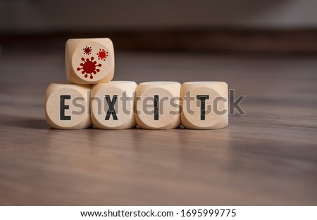 Cubes and dice with corona virus icons and exit strategy on wooden background