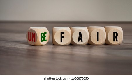 Cubes And Dice With Fair And Unfair On Wooden Background