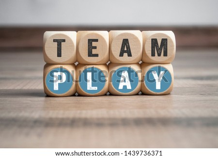 Cubes and dice with Team Play on wooden background