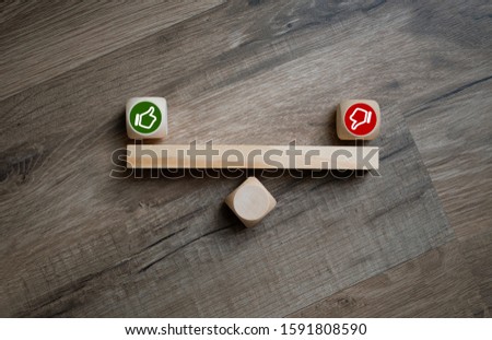 Cubes dice with thumbs up and down on wooden background