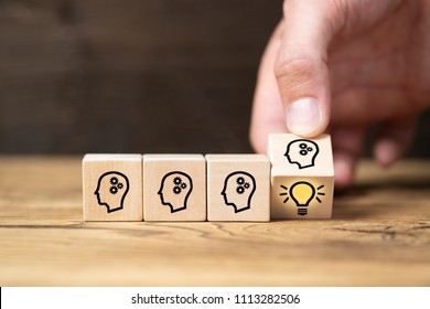 cubes with head symbols and hand that flips one revealing an idea - Shutterstock ID 1113282506